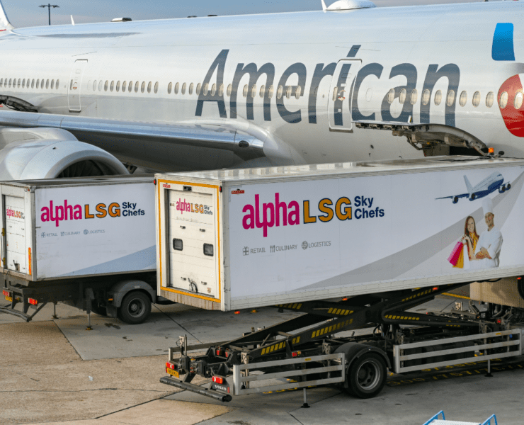 two catering trucks at the side of an American Airlines aircraft