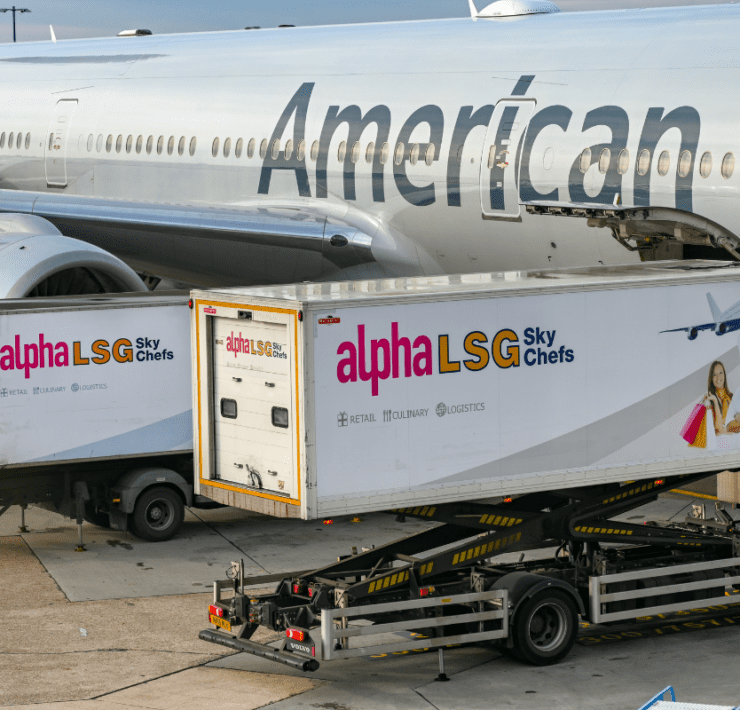 two catering trucks at the side of an American Airlines aircraft