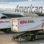 two catering trucks at the side of an American Airlines aircraft