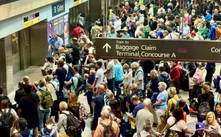 a crowd of people waiting to board a train at denver airport