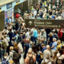 a crowd of people waiting to board a train at denver airport