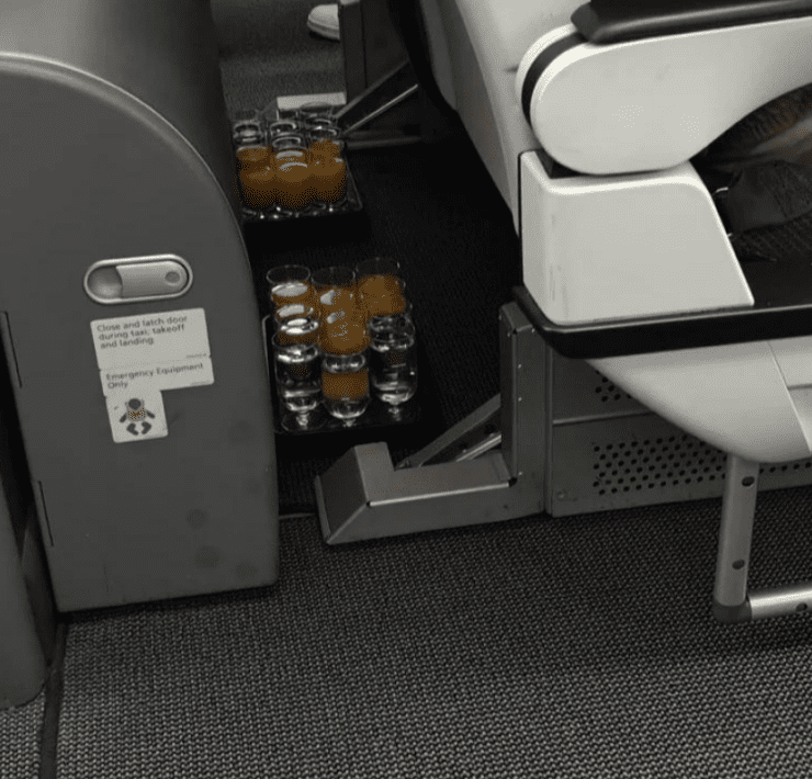 two trays of drinks left on floor of plane