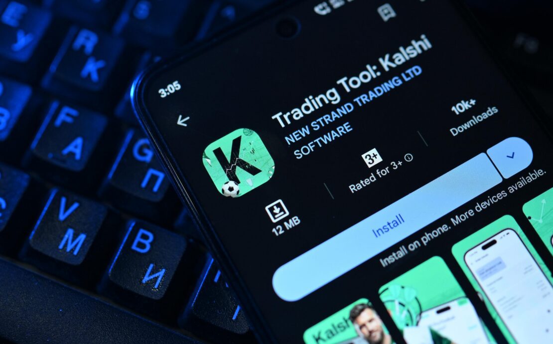 an image of a mobile phone displaying the Kalshi prediction markets map on top of a keyboard