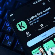 an image of a mobile phone displaying the Kalshi prediction markets map on top of a keyboard