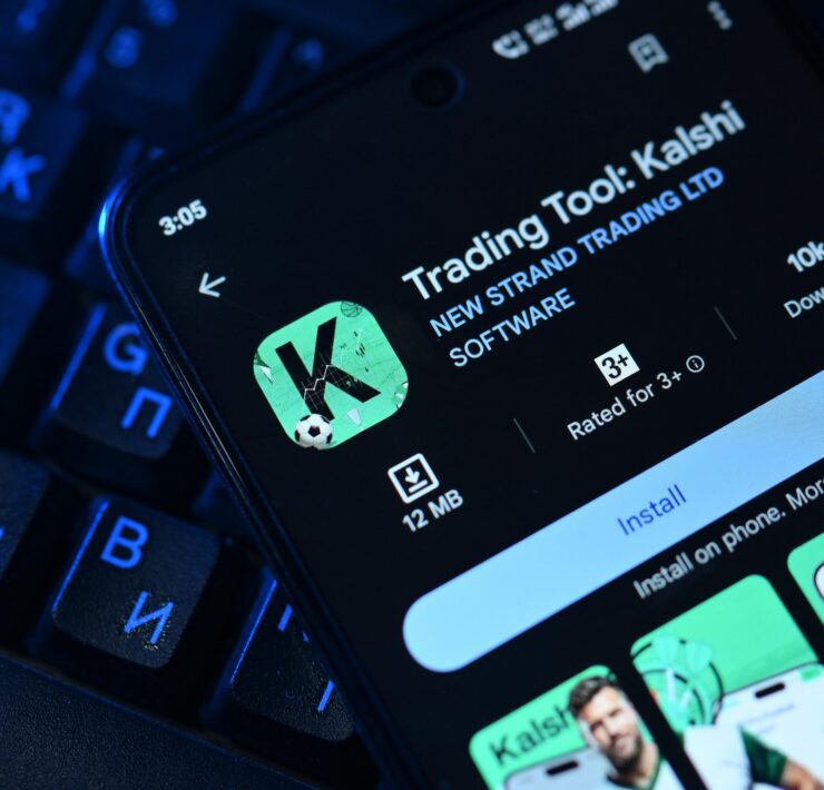 an image of a mobile phone displaying the Kalshi prediction markets map on top of a keyboard